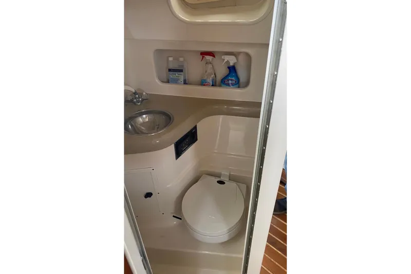 Slide: The Image of Compact bathroom in 2001 Pursuit 3000 Express boat with sink and toilet. - 8