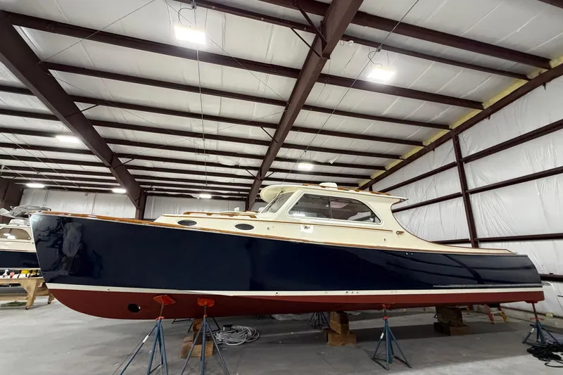 Slide: The Image of 2003 Hinckley Picnic Boat 36 EP in storage, side view in a warehouse. - 10