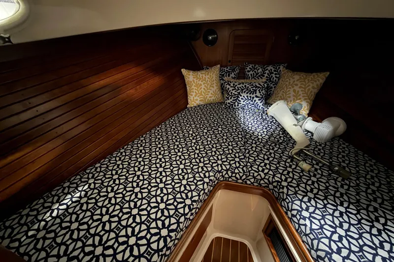 Slide: The Image of Cozy cabin interior of 2003 Hinckley Picnic Boat 36 EP with patterned bedding and pillows. - 9