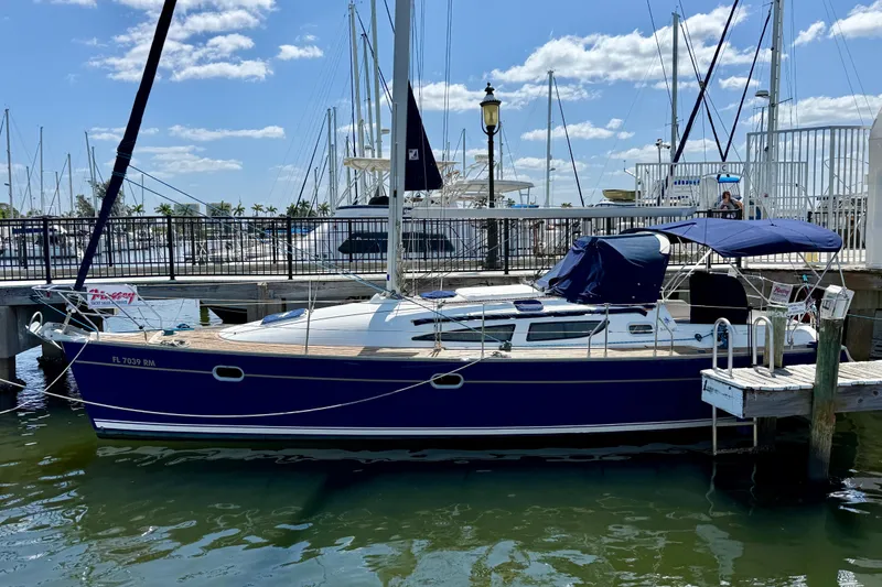 The Image of 2004 Jeanneau Sun Odyssey 35 sailboat docked at marina under blue sky. - 1