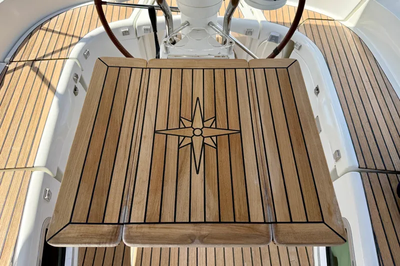 Slide: The Image of Teak cockpit table on 2004 Jeanneau Sun Odyssey 35 sailboat, featuring compass rose design. - 19