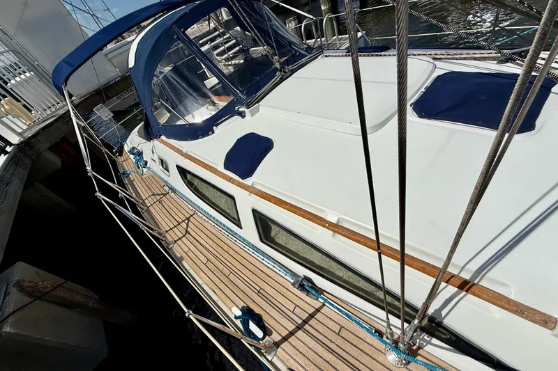 Slide: The Image of 2004 Jeanneau Sun Odyssey 35 sailboat docked, featuring a sleek deck and blue canopy. - 25