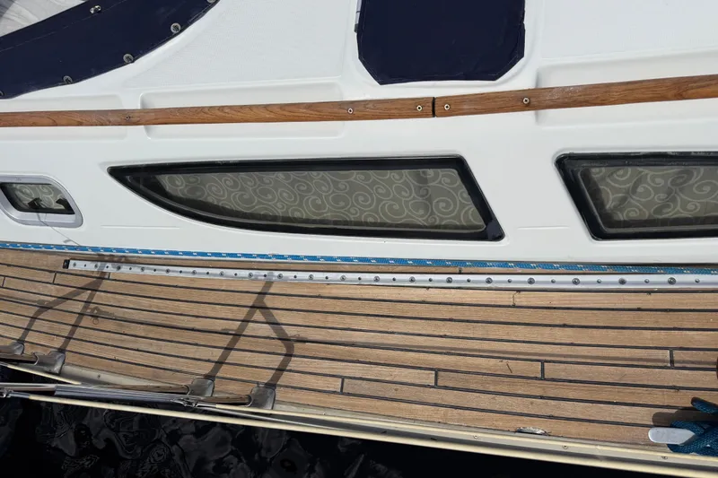 Slide: The Image of 2004 Jeanneau Sun Odyssey 35 sailboat deck with wooden finish and cabin windows. - 26