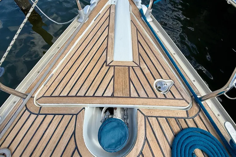 Slide: The Image of Deck of 2004 Jeanneau Sun Odyssey 35 sailboat with teak finish and blue rope. - 33