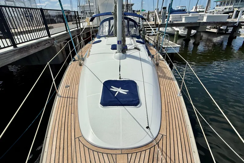 Slide: The Image of 2004 Jeanneau Sun Odyssey 35 sailboat docked at marina, showcasing teak deck and rigging. - 36