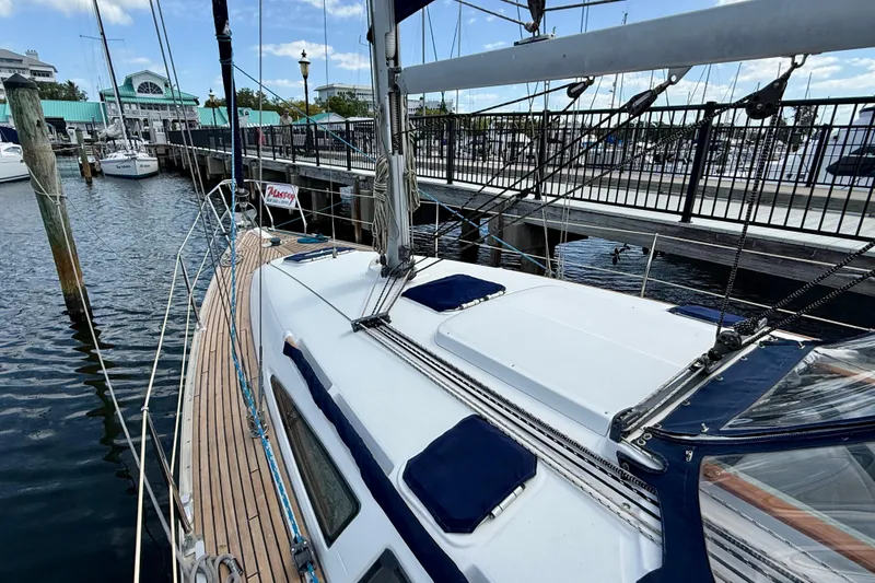 Slide: The Image of 2004 Jeanneau Sun Odyssey 35 sailboat docked at marina, showcasing deck and rigging. - 38