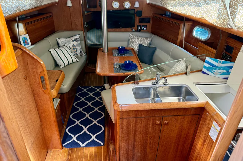 Slide: The Image of Interior of 2004 Jeanneau Sun Odyssey 35 sailboat with cozy seating and dining area. - 39