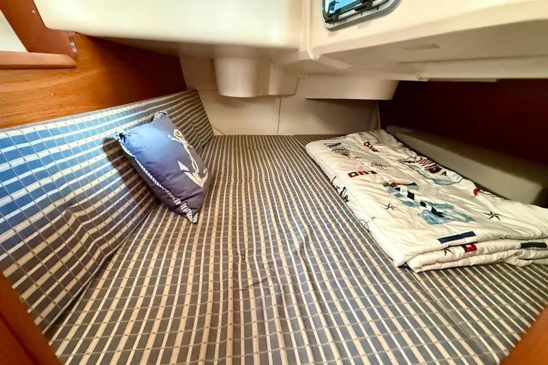 Slide: The Image of Cozy cabin interior of 2004 Jeanneau Sun Odyssey 35 sailboat with nautical-themed bedding. - 42