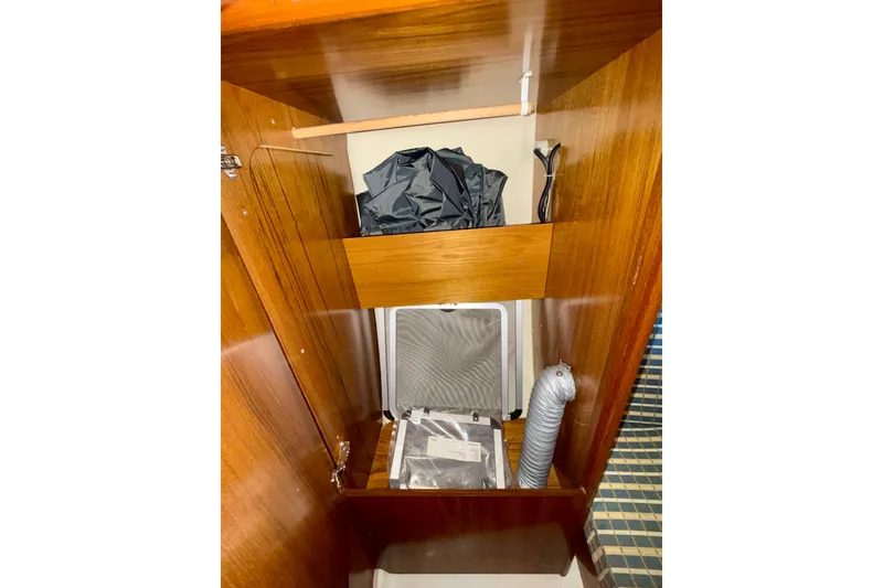 Slide: The Image of Interior storage of 2004 Jeanneau Sun Odyssey 35 sailboat with wooden shelves and equipment. - 43