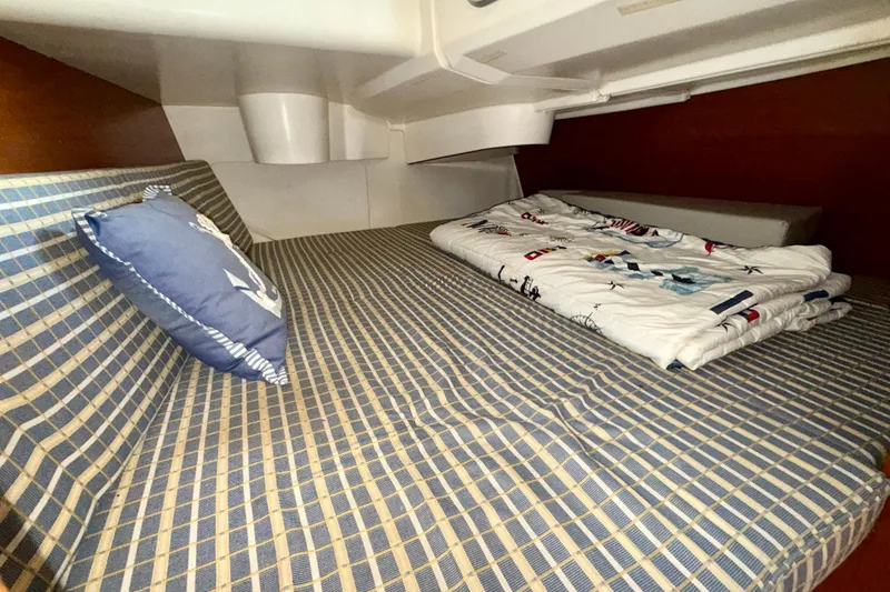 Slide: The Image of Cozy cabin interior of 2004 Jeanneau Sun Odyssey 35 sailboat with nautical bedding. - 46