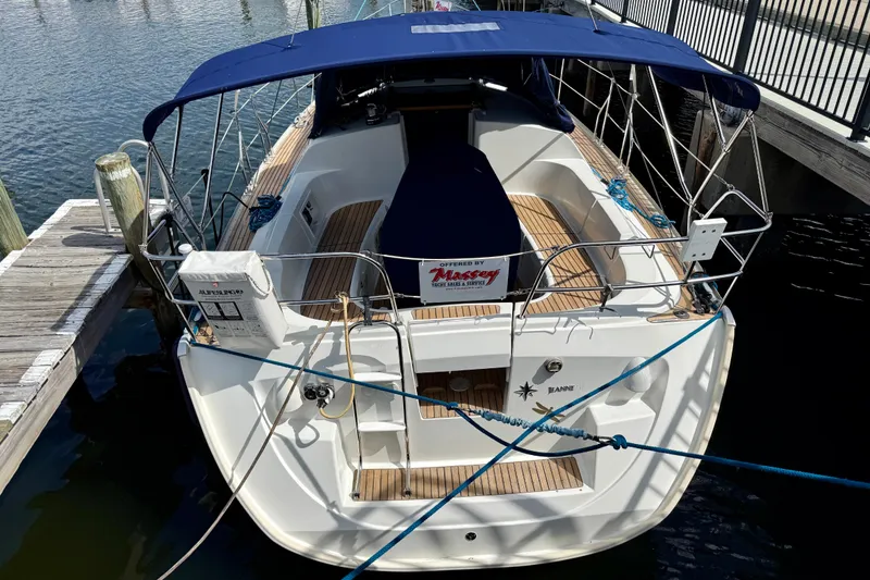 Slide: The Image of 2004 Jeanneau Sun Odyssey 35 sailboat docked with blue canopy and wooden deck. - 5
