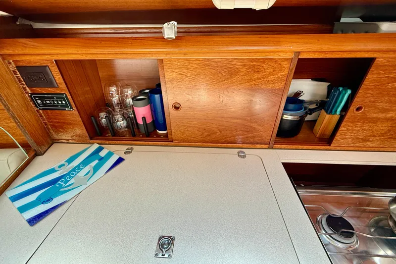 Slide: The Image of Interior of 2004 Jeanneau Sun Odyssey 35 yacht with wooden cabinets and kitchen essentials. - 51