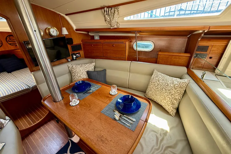 Slide: The Image of Interior of 2004 Jeanneau Sun Odyssey 35 sailboat with cozy dining area and elegant wood finish. - 53
