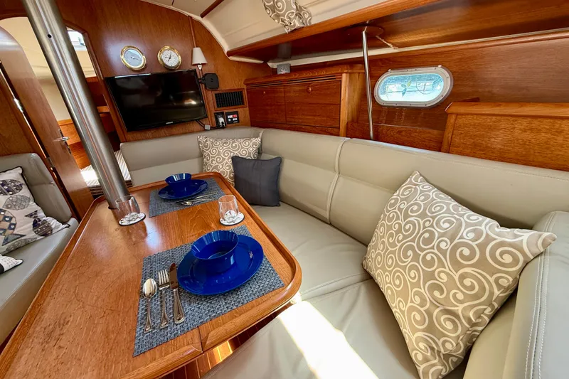 Slide: The Image of Luxurious interior of 2004 Jeanneau Sun Odyssey 35 sailboat with elegant dining setup. - 54