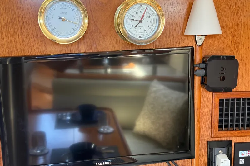 Slide: The Image of Interior of 2004 Jeanneau Sun Odyssey 35 with TV, barometer, and Apple TV device. - 56