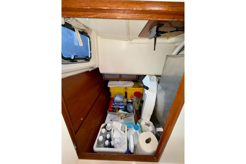 Slide: The Image of Storage compartment on a 2004 Jeanneau Sun Odyssey 35 sailboat, filled with supplies. - 62