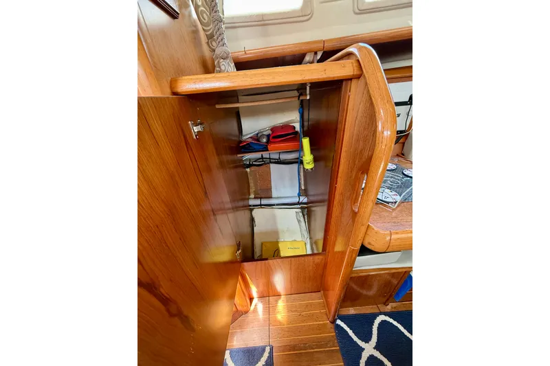 Slide: The Image of Interior view of a 2004 Jeanneau Sun Odyssey 35 sailboat, showcasing wooden cabinetry and storage. - 64