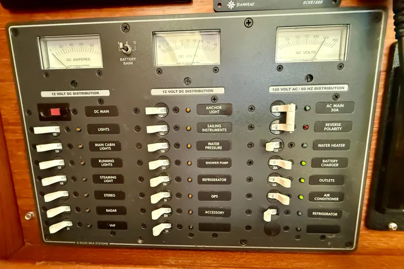 Slide: The Image of Electrical control panel on a 2004 Jeanneau Sun Odyssey 35 sailboat, featuring various switches and gauges. - 67