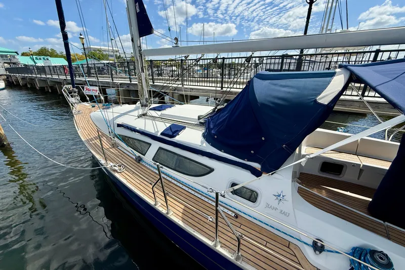 Slide: The Image of 2004 Jeanneau Sun Odyssey 35 sailboat docked at marina under blue sky. - 7