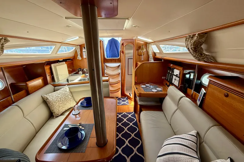 Slide: The Image of Interior of 2004 Jeanneau Sun Odyssey 35 sailboat, featuring cozy seating and elegant wood finishes. - 77