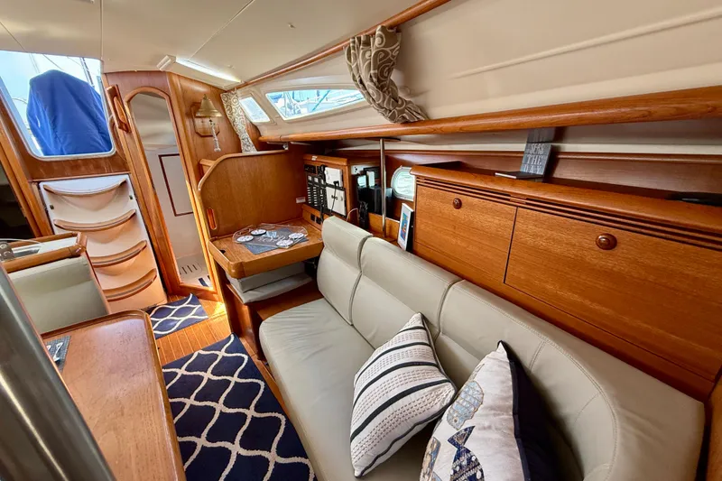 Slide: The Image of Interior of 2004 Jeanneau Sun Odyssey 35 yacht with cozy seating and wooden cabinetry. - 78