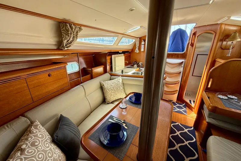 Slide: The Image of Interior of 2004 Jeanneau Sun Odyssey 35 sailboat, featuring cozy seating and elegant wood finishes. - 79