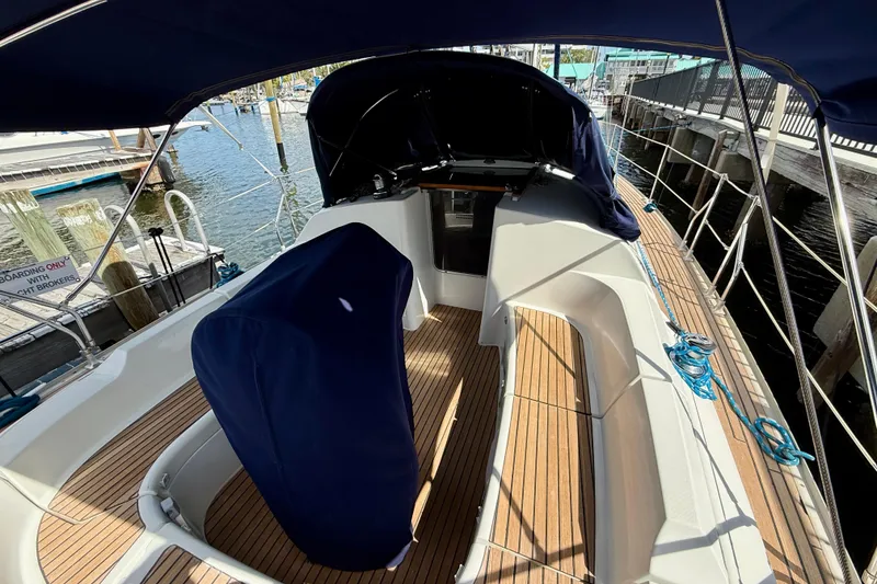 Slide: The Image of 2004 Jeanneau Sun Odyssey 35 sailboat cockpit with blue canopy and wooden deck. - 8
