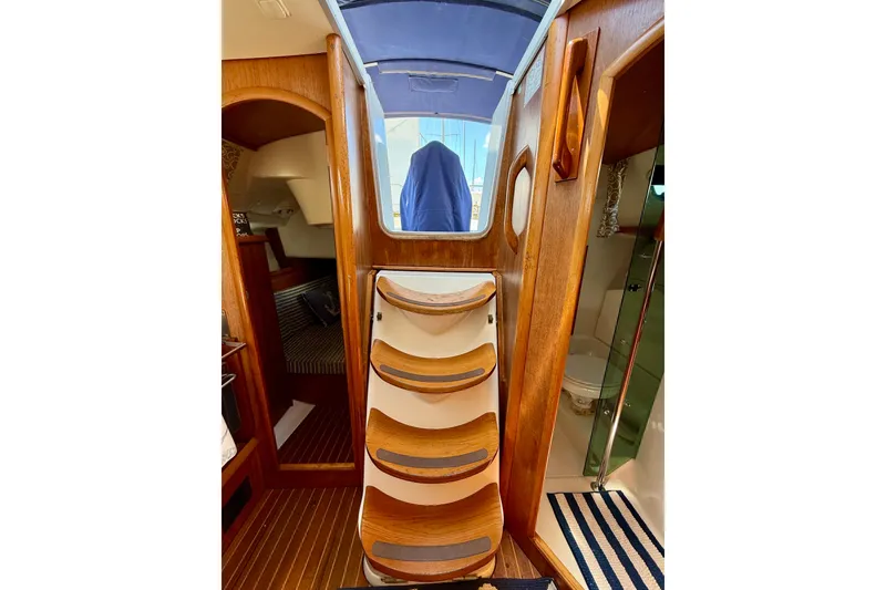 Slide: The Image of Interior view of 2004 Jeanneau Sun Odyssey 35 sailboat with wooden steps and cabin access. - 81