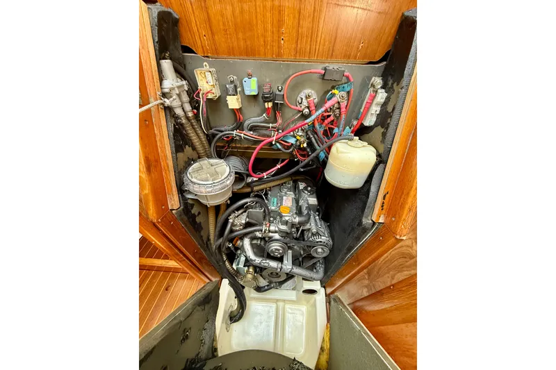 Slide: The Image of Engine compartment of a 2004 Jeanneau Sun Odyssey 35 sailboat, showing wiring and components. - 82