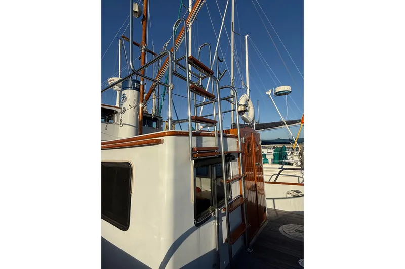 Slide: The Image of 1987 Lord Nelson Victory Tug with polished wood and metal details, docked under clear skies. - 15