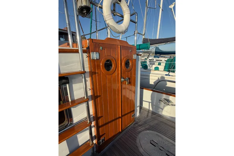 Slide: The Image of Wooden door on 1987 Lord Nelson Victory Tug boat deck with portholes and life preserver. - 17