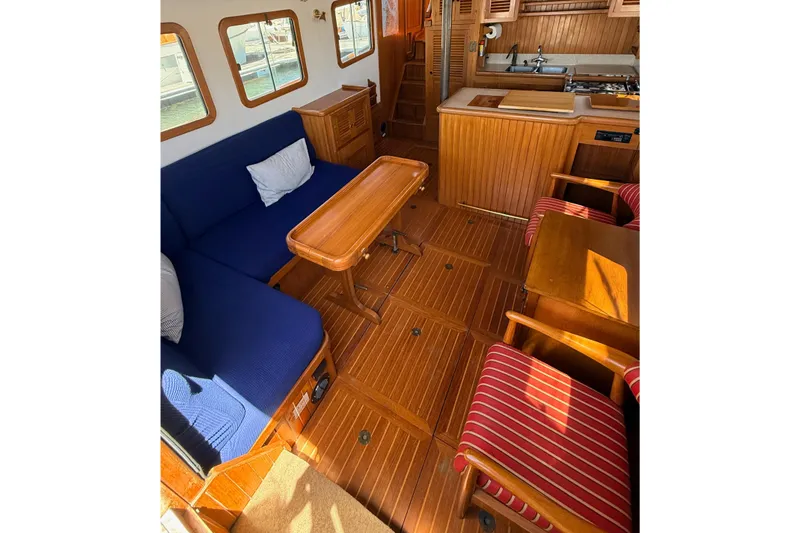 Slide: The Image of Interior of 1987 Lord Nelson Victory Tug with wooden furnishings and blue seating. - 21