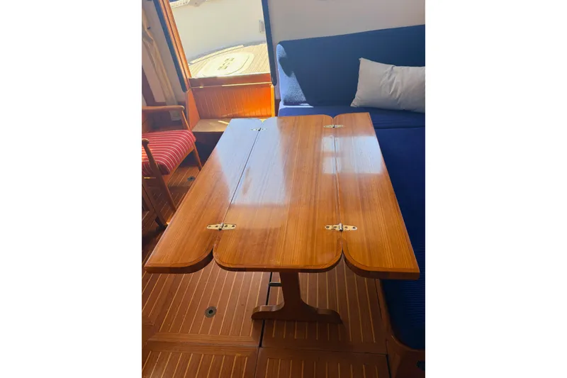 Slide: The Image of Interior of 1987 Lord Nelson Victory Tug with wooden table and seating area. - 24