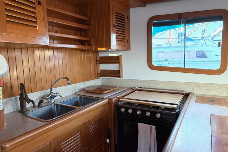Slide: The Image of Wooden kitchen interior of 1987 Lord Nelson Victory Tug with sink and stove. - 25