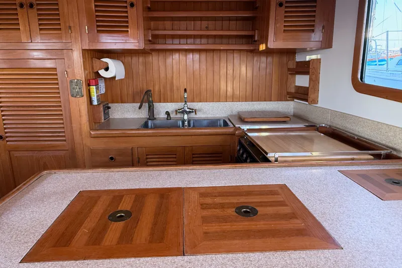 Slide: The Image of 1987 Lord Nelson Victory Tug kitchen with wooden cabinetry and dual sinks. - 27