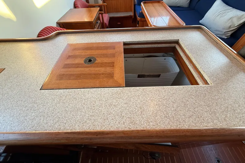 Slide: The Image of 1987 Lord Nelson Victory Tug interior with wooden table and hidden storage compartment. - 28