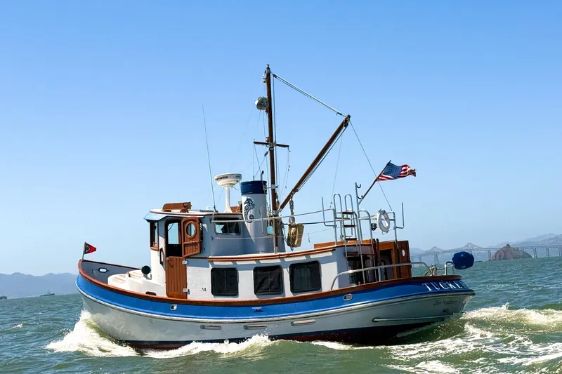 Slide: The Image of 1987 Lord Nelson Victory Tug boat cruising on open water with American flag. - 3