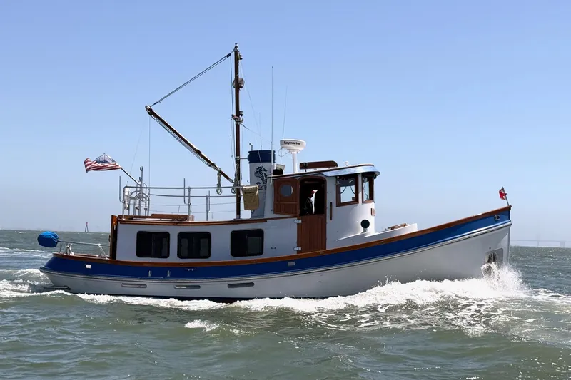 Slide: The Image of 1987 Lord Nelson Victory Tug cruising on open water, displaying classic nautical design. - 4