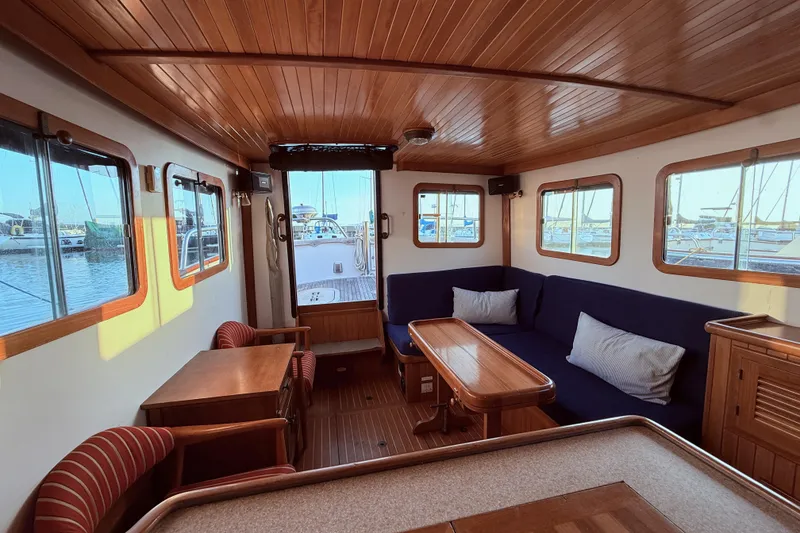 Slide: The Image of Interior of 1987 Lord Nelson Victory Tug with wooden furnishings and marina view. - 42