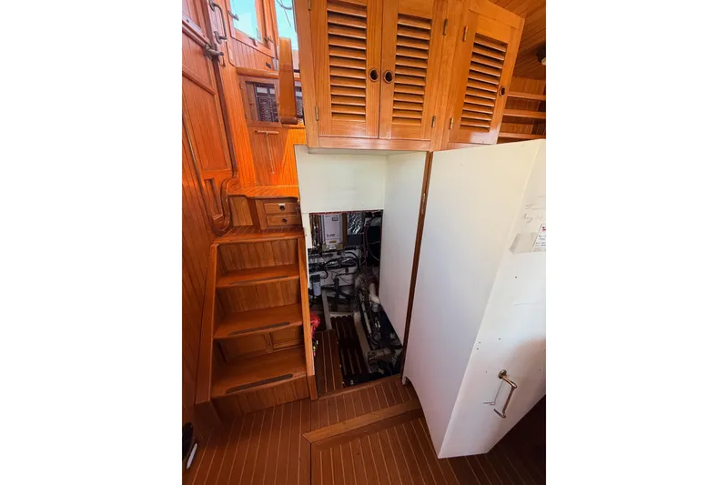 Slide: The Image of Engine room access in 1987 Lord Nelson Victory Tug, featuring wooden interior and stairs. - 44