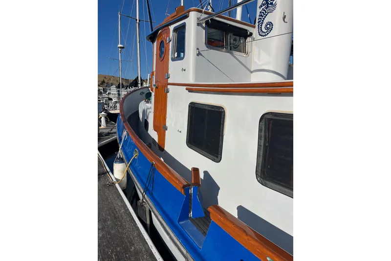 Slide: The Image of 1987 Lord Nelson Victory Tug boat with wooden accents docked at marina. - 8