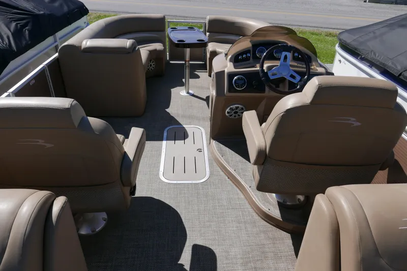 Slide: The Image of Interior of a 2016 Bennington 2250GSR pontoon boat with beige seating and steering console. - 11