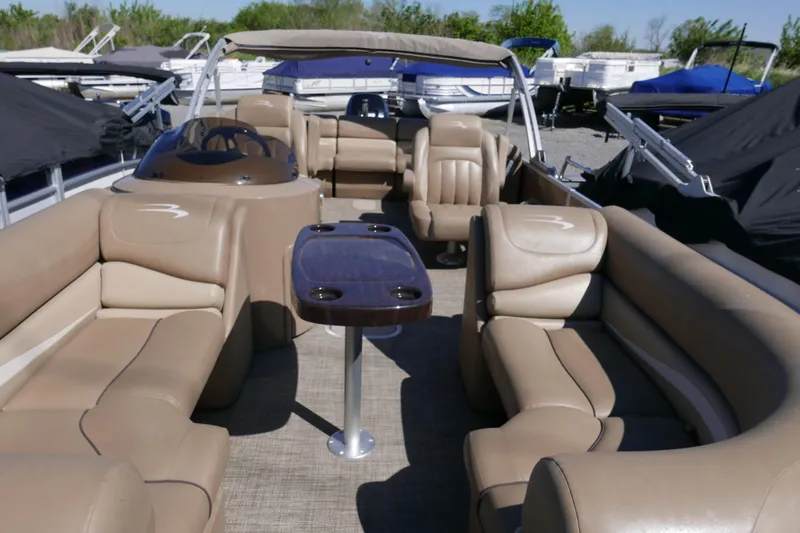 Slide: The Image of 2016 Bennington 2250GSR pontoon boat interior with beige seating and central table. - 3