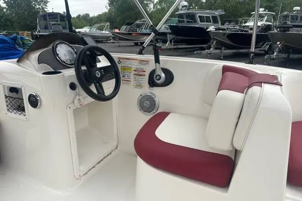 Slide: The Image of 2016 Bayliner 160 Element boat interior with steering wheel and maroon seating. - 4