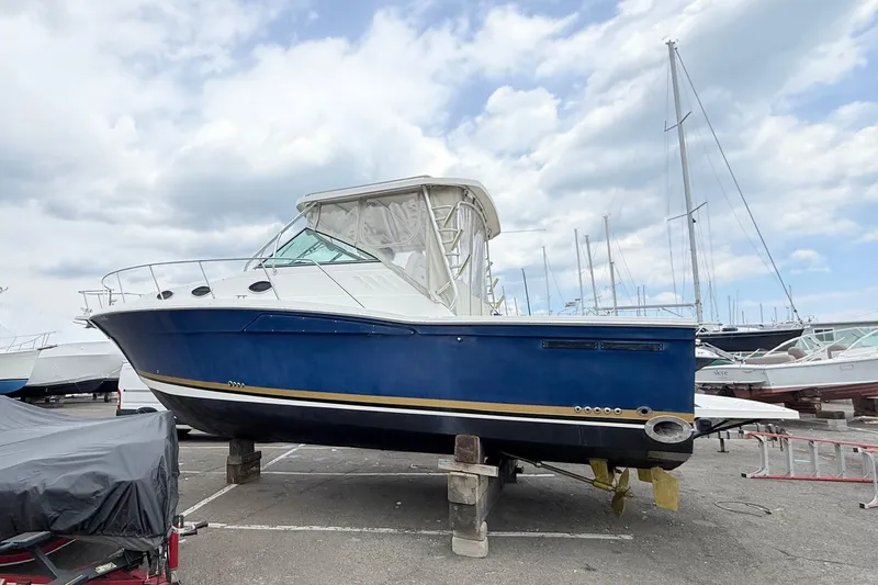 The Image of 2004 Wellcraft 330 Coastal boat on dry dock under cloudy sky. - 0
