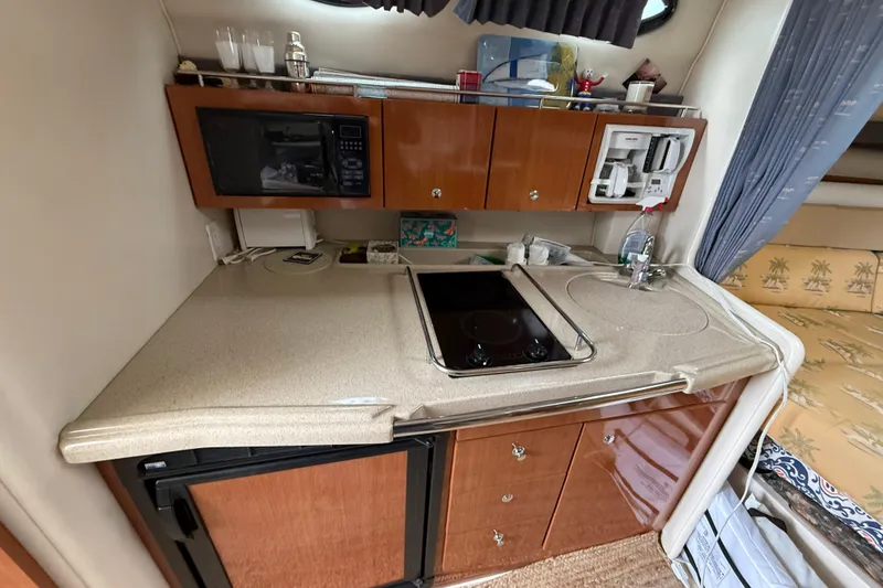 Slide: The Image of 2004 Wellcraft 330 Coastal boat kitchen with microwave, stove, and sink. - 12
