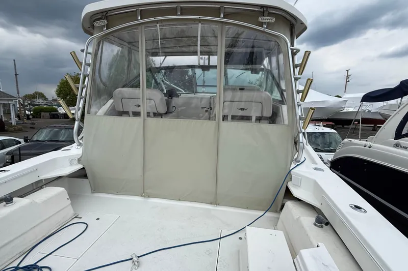 Slide: The Image of 2004 Wellcraft 330 Coastal boat with enclosed cockpit, docked under cloudy skies. - 14
