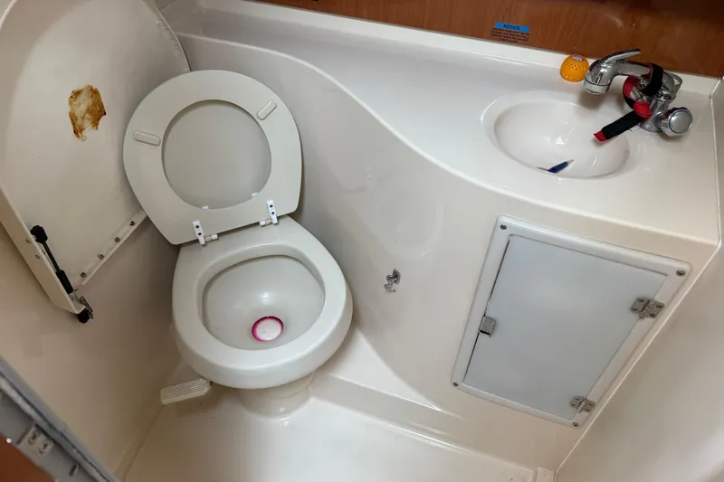 Slide: The Image of Compact marine bathroom in 2004 Wellcraft 330 Coastal boat, featuring toilet and sink. - 16