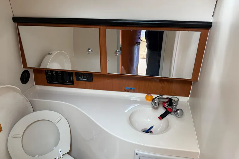 Slide: The Image of 2004 Wellcraft 330 Coastal bathroom with sink, mirror, and toilet. - 17
