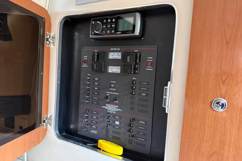 Slide: The Image of Electrical panel inside a 2004 Wellcraft 330 Coastal boat, featuring control switches and a radio. - 18